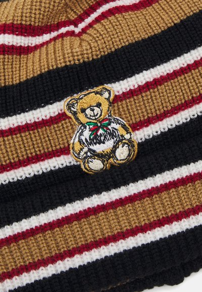 Randig stickad mössa i brunt, svart, rött och vitt. Har en broderad nallebjörnsapplikation på framsidan, vilket framhäver dess design och textur.
