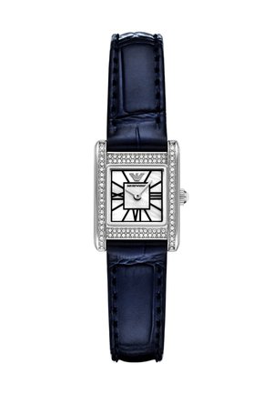 Rechteckige Armbanduhr aus Edelstahl mit einem Zifferblatt aus weißem Perlmutt und schwarzen geometrischen Markierungen, umrahmt von einer Reihe klarer Kristalle, und einem navyblauen Lederband.