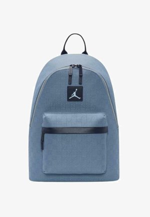 Zaino in tessuto blu con tasca frontale con zip, dettagli neri e un patch logo con silhouette. Tessuto liscio e forma arrotondata.