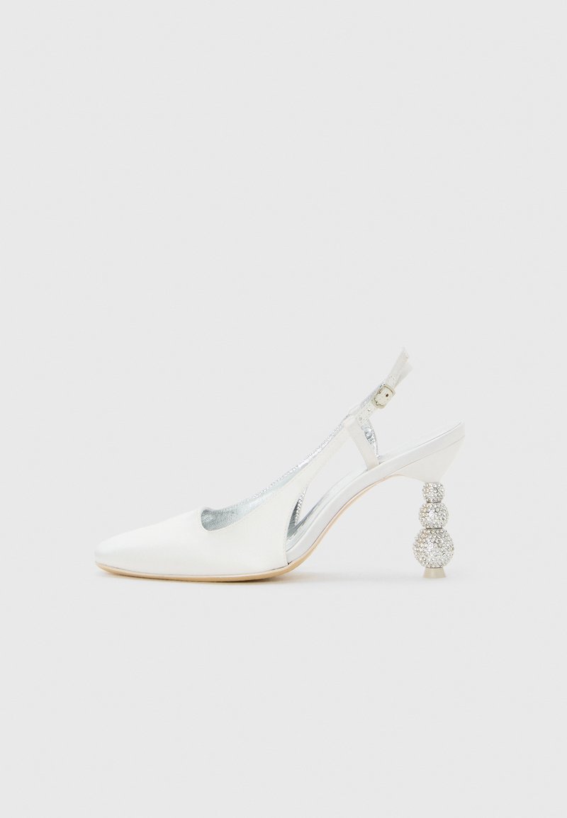 Λευκό δερμάτινο ψηλοτάκουνο παπούτσι slingback με μυτερή μύτη και διακοσμητικό τακούνι στρογγυλής μορφής στολισμένο με ριγιόν, σε απλό φόντο.