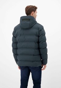 Ciemnozielona pikowana kurtka z poziomym przeszyciem i kapturem. Na plecach znajduje się naszywka z logo, a materiał ma gładką, błyszczącą fakturę.