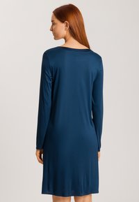 Vestido de manga larga en azul marino, hecho de tejido suave y ligero. Hasta la rodilla, con un escote redondo y un diseño minimalista, sin patrones ni acentos.