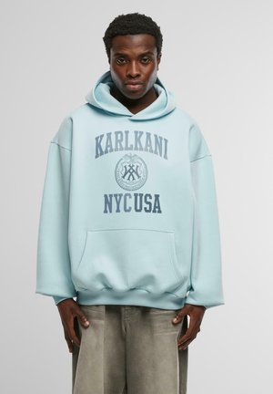 Himmelblauer Hoodie mit einer Fronttasche, der ein kreisförmiges grafisches Design mit grauem Text aufweist, das "KARLKANI NYcUSA" liest. Strukturiertes Material, oversized Schnitt.