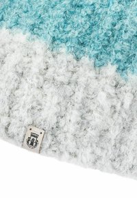 Knitted beanie with a textured, fluffy surface. Color gradient transitions from teal at the top to light gray at the bottom. Label on side.