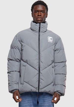 Gray puffer jacket with a high collar, diagonal quilted pattern, front zipper, and an embroidered logo on the upper left chest.