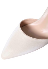 Scarpa con tacco alto in satin beige, con punta affusolata e lati aperti, caratterizzata da una texture liscia e da un tacco snodato e allungato.