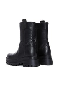 Botas de tobillo de cuero negro con una textura suave, suela gruesa, cremallera trasera y tira para un fácil calzado. Presentan un diseño robusto y resistente.