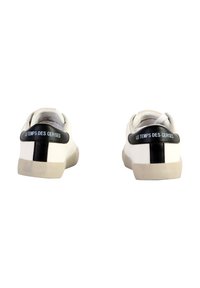 Zapatillas de cuero blancas con un acento negro en el talón que lleva el texto "LE TEMPS DES CERISES", punta redonda y suela de goma beige.