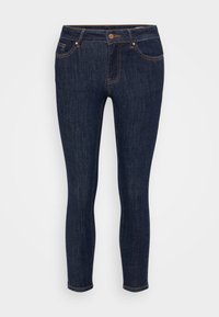 Jeans ajustados de mezclilla azul oscuro con costuras naranjas, cremallera, cinco bolsillos y un diseño ceñido al cuerpo. Textura suave y tiro estándar.