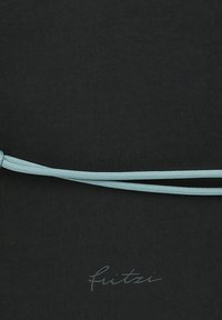 Un textil negro con una textura suave presenta un cordón de color azul claro. La palabra "fuitzi" está sutilmente impresa en un estilo cursivo.