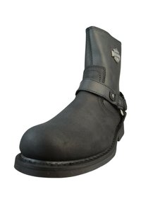 Botte noire en cuir à cheville avec un bout arrondi, une sangle latérale et des accents métalliques. Caractéristiques d'une semelle robuste et de détails de couture visibles.