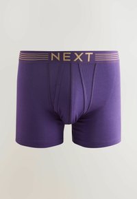 Lila boxer alsónemű, puha anyagból, arany "NEXT" logóval a csíkozott derékrészen, testhezálló fazonban és kontúros tasakkal.