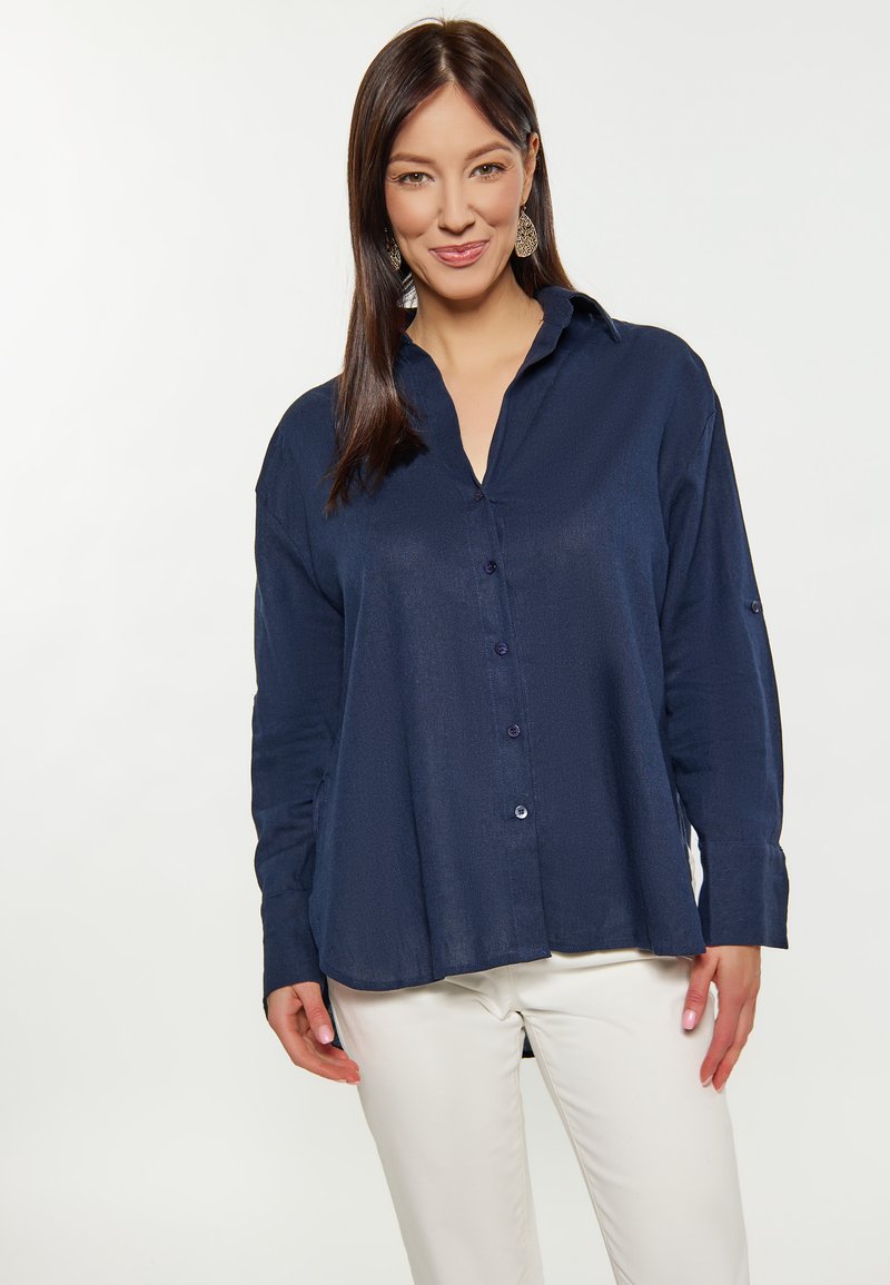 Camicia a maniche lunghe blu navy realizzata in un tessuto liscio e texture, con chiusura a bottoni e un fit rilassato con orlo curvo.