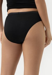 Zwarte katoenen hipsteronderbroek met een gladde textuur, met een strakke pasvorm en minimale stiksels langs de randen, zonder extra accenten.