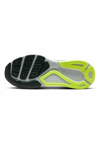 Sole di scarpa sportiva con motivi di trazione nera in gomma, intersuola grigia con vivaci accenti verde neon e superficie testurizzata.