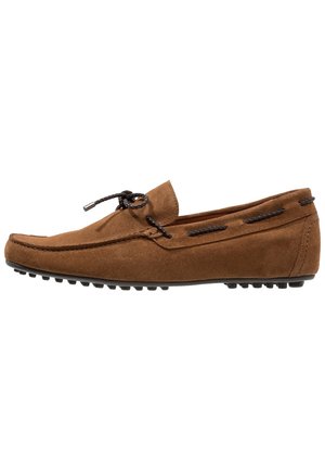 Mocassin en daim marron avec lacet tressé noir noué en nœud, détails cousus et semelle en caoutchouc avec crampons antidérapants.