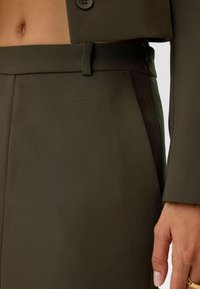 Olijfgroene op maat gemaakte broek met een rechte voorkant, zijzakken en een gladde stoftextuur. De tailleband is voorzien van een ritsluiting.