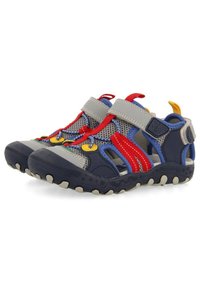 Sandalias de malla azules y grises con acentos rojos, correas de velcro, suelas texturizadas, herrajes coloridos y diseño de punta cerrada.
