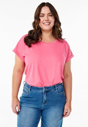 Rosa kortärmad t-shirt med rund halsringning, matchad med högmidjade jeans i denim. Tyget ser slätt och lätt ut.