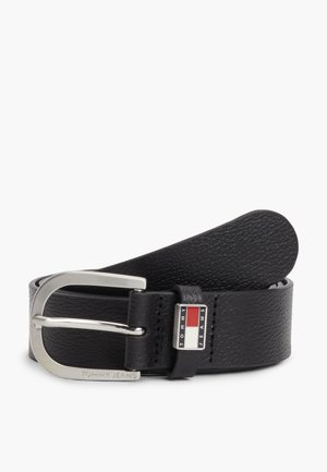 Cinturón de cuero negro con textura, hebilla rectangular plateada y una pequeña etiqueta con el logo de la bandera que dice Tommy Jeans.