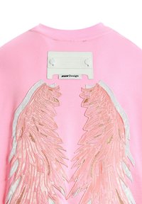 Sudadera rosa con alas bordadas en dorado y blanco. Incluye una etiqueta blanca en el cuello con detalles de la marca.