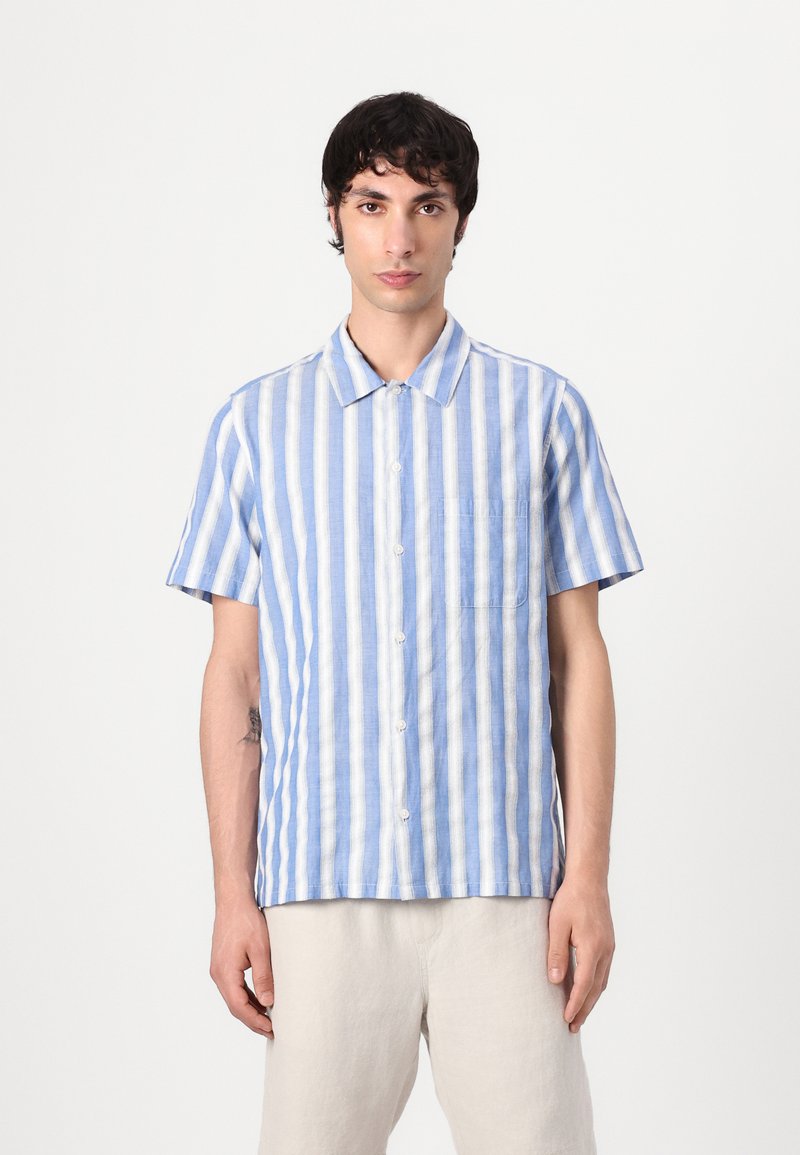 Camicia a maniche corte con righe verticali blu e bianche, realizzata in tessuto leggero, con bottone frontale e taschino sul petto.