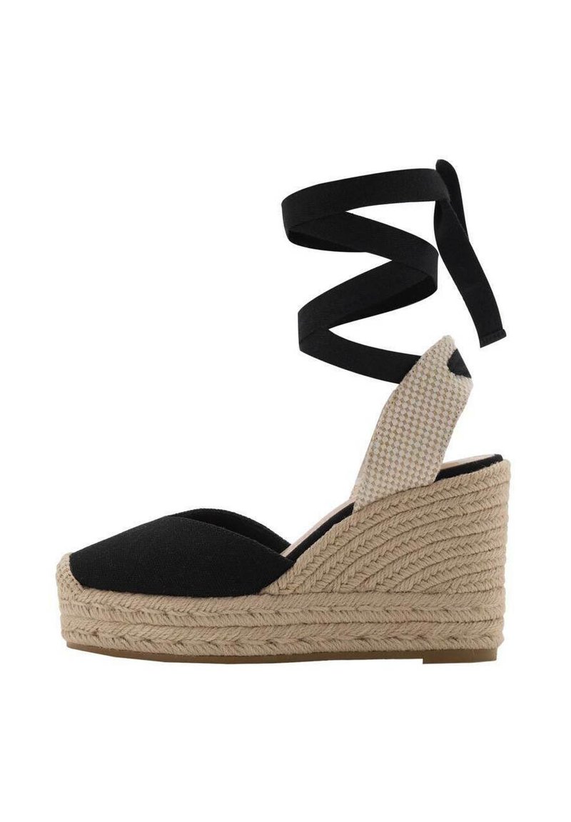 Sandale cu toc espadrille din țesătură neagră, cu talpă din jute împletit, accente maronii și curele lungi negre care se înfășoară în jurul gleznei.