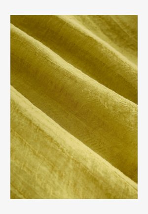 Tekstilna tkanina v živahni gorčični rumeni barvi, ki ima teksturirano površino z rahlimi ribjimi vzorci in mehkimi gubami.