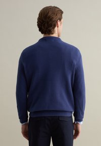 Navy blue textured sweater with a relaxed fit and ribbed cuffs. Features a round neckline and a smooth hem at the waist.
