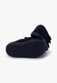 Zapatillas de ante azul marino con una suela blanda, que presentan bordes redondeados, una correa de gancho y bucle, y una suela de goma texturizada para mayor agarre.