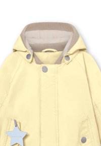Veste légère jaune avec capuche, dotée d'une doublure beige douce, de boutons-pression, de deux poches latérales et d'une étiquette en étoile bleue.