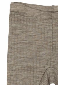 Brūnas teksturētas legingi ar austu rakstu, elastīgu jostu un bezšuvju dizainu ar potītes griezumu, izgatavoti no stieptā materiāla.