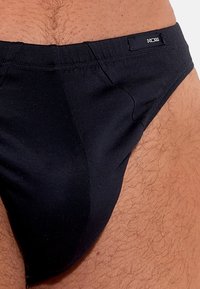 Schwarze Baumwollunterwäsche mit glatter Textur, ausgestattet mit einem Markenbund und einem tief sitzenden Design für eine enge Passform.