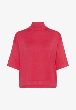 Lyhythihainen korkeakauluspaita kirkkaan korallin värissä. Valmistettu pehmeästä, kevyestä kankaasta, jossa on rento istuvuus ja suora helma.