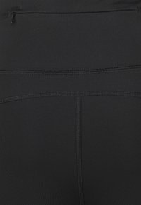 Svarta atletiska leggings med en slät yta, hög midja och subtila sömdetaljer. Inkluderar en liten dragkedjeficka på baksidan.