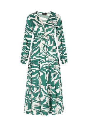 Zielona i biała maxi sukienka z długimi rękawami, dekoltem w kształcie litery V oraz paskiem do związania w talii. Charakteryzuje się ogólnym abstrakcyjnym wzorem w paski tygrysa oraz warstwowym krojem.