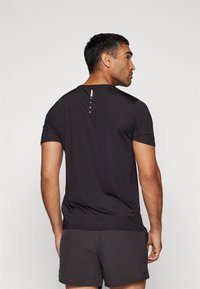 Puma FLEX TEE - Sports T-shirts - black