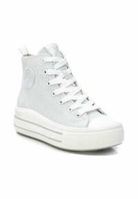 Zapatillas altas de lona gris claro con cordones blancos, suela de goma texturizada y un logo circular en el lateral.