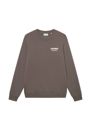 Καφέ φούτερ από μαλακό ύφασμα, με μακριά μανίκια, στρογγυλή λαιμόκοψη και λευκό λογότυπο στο στήθος. Ριμπέ μανσέτες και στρίφωμα.