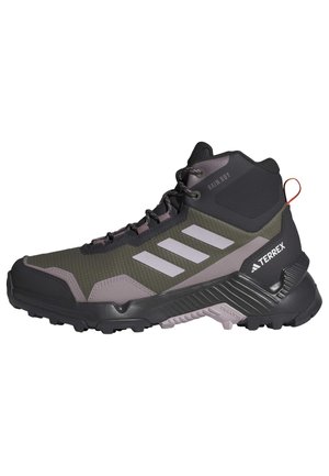 Bota de senderismo de caña alta en negro y verde olivo con acentos grises, parte superior de malla texturizada, cuello acolchado y suela resistente para tracción.
