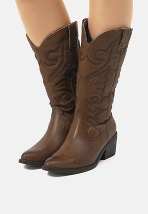 Botas de vaquero de cuero marrón con punteras puntiagudas, detalles bordados, tacones de altura media y cremalleras laterales para facilitar su uso.