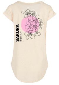 Cremefarbenes T-Shirt mit floralem Design, pinken Akzenten und schwarzem Text "SAKURA" auf der Rückseite. Weicher Stoff und abgerundeter Saum.