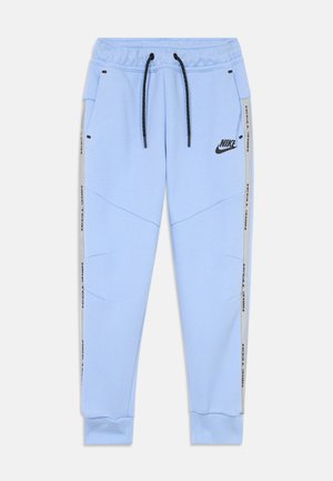 Pantaloni jogger Nike Tech blu chiaro con lacci neri, tasche laterali, pannelli grigi e logo Nike nero sulla coscia sinistra.