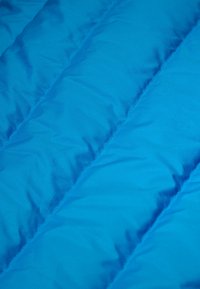 Matière de doudoune bleu vif avec une texture lisse, présentant des sections matelassées horizontales et un motif à carreaux subtil.