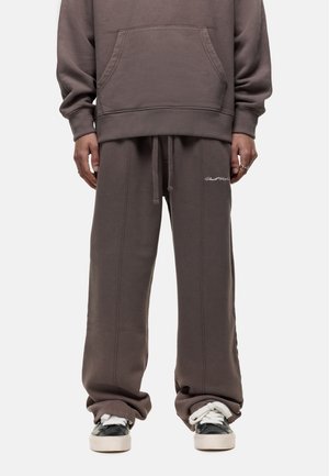 Oversized gray hoodie with a front pocket, paired with loose gray sweatpants featuring drawstring waist and embroidered logo.