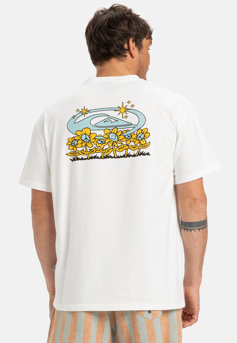 White t-shirt featuring a colorful floral design and stars on the back. Short sleeves and a relaxed fit with a smooth texture.
