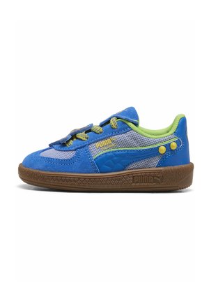 Niebiesko-szary sneaker Puma z zielonym wkładem, żółtymi akcentami i brązową podeszwą, zaprojektowany dla dzieci z zapięciem na rzep i sznurówkami.