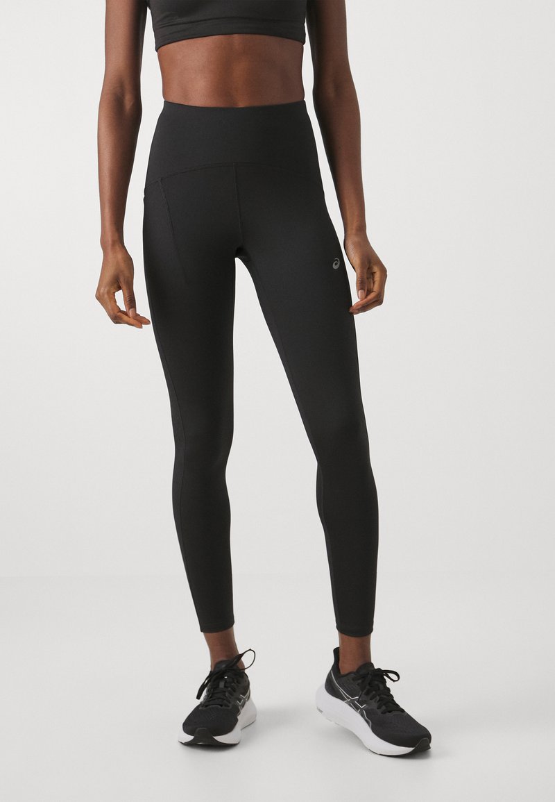 Black high-waisted leggings made of stretchy fabric, featuring a side pocket and an Asics logo on the lower leg. Smooth texture.