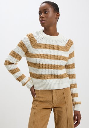 Maglione lavorato a maglia con righe verticali bianche e beige, polsini e orlo a coste, girocollo e finitura texturizzata. Abbinato a pantaloni in corduroy beige.