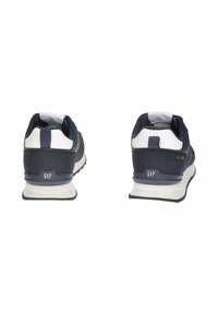 Un paio di sneakers navy blue e bianche GAP viste da dietro, con suole bianche e linguette per il tallone su uno sfondo bianco.